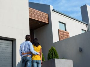 A couple standing in front of their new modern home